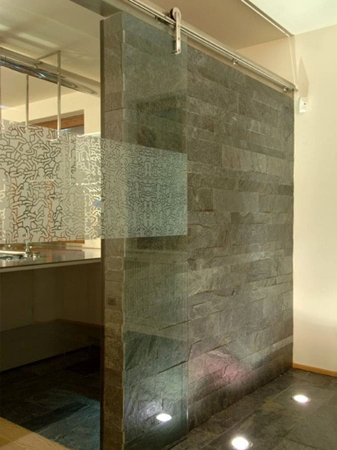Rivestimento in pietra in ardesia grigia installato all'interno di un box doccia
